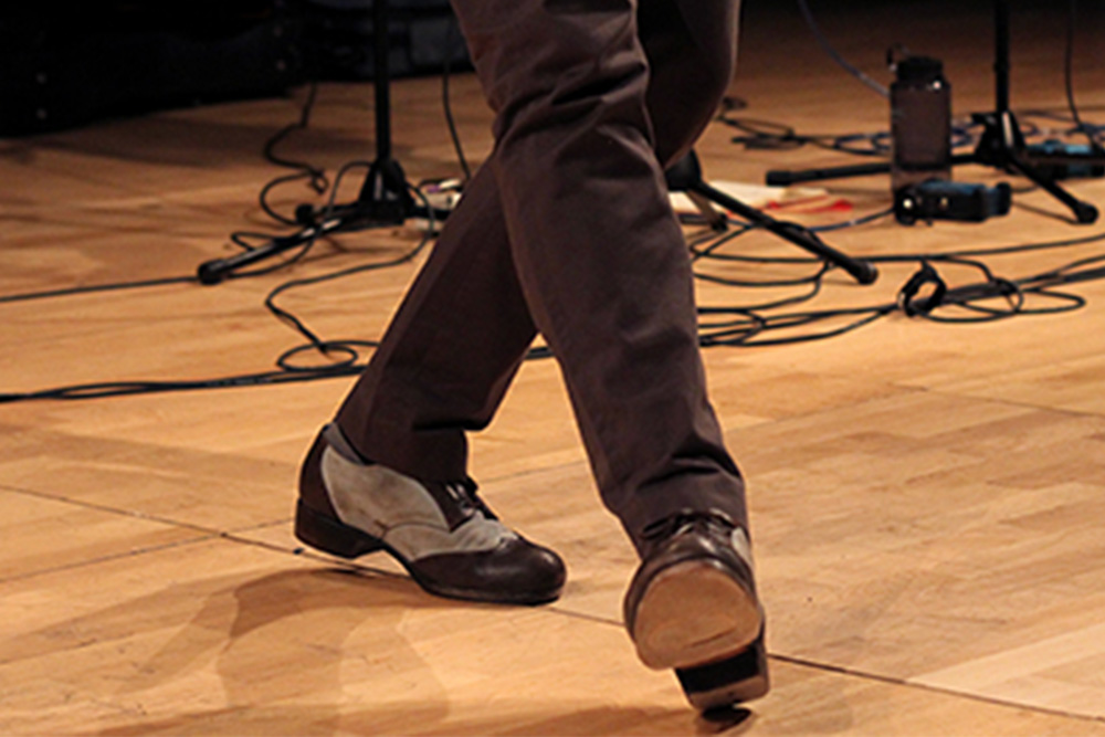 A person's legs while wearing tap dance shoes